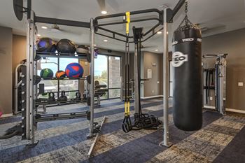 a gym with a punching bag and weights on a rack  at Watermark on Twenty Mile, Parker